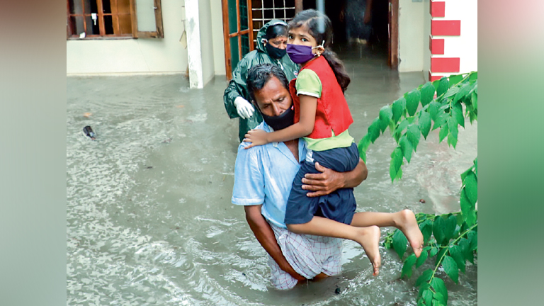 കടലാക്രമണത്തെ തുടർന്ന് വെള്ളം കയറിയ ചെല്ലാനത്തെ വീട്ടിൽനിന്ന്  സുരക്ഷിത സ്ഥലത്തേക്ക്  മാറുന്നവർ