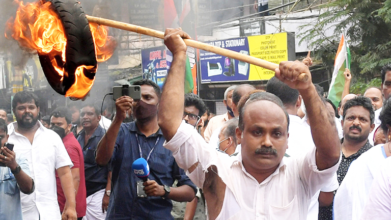 ആലുവയിലെ എസ്-പി ഓഫീസിലേക്ക് കോൺഗ്രസ് നടത്തിയ മാർച്ചിൽ പ്രവർത്തകൻ ടയർകത്തിച്ച്  പൊലീസിനുനേരെ എറിയുന്നു |  ഫോട്ടോ: മനു വിശ്വനാഥ്