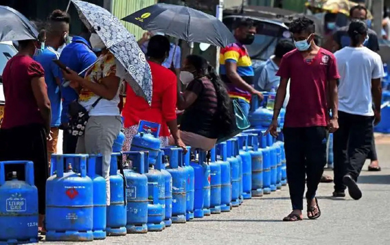 സാമ്പത്തിക മാന്ദ്യ കാലത്ത്‌ ഗ്യാസ്‌ നിറയ്‌ക്കാൻ സിലിണ്ടറുകളുമായി  വരി നിൽക്കുന്ന ജനങ്ങൾ. കൊളംബോയിൽ നിന്നുള്ള കാഴ്‌ച - കടപ്പാട്‌: AFP